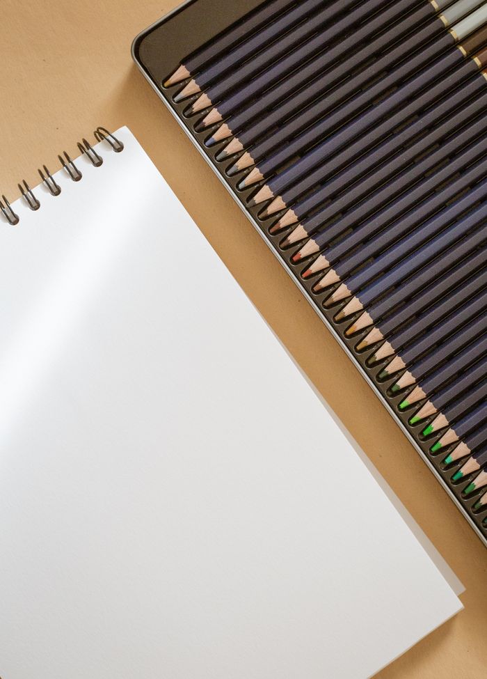 An open sketchbook with colored pencils ready for artistic creativity.